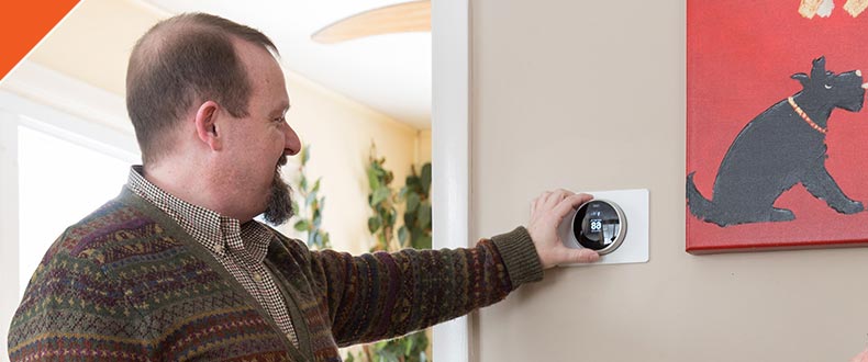 Man adjusting thermostat